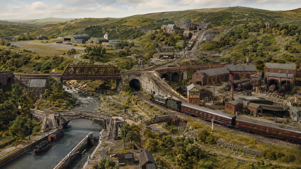 A richly layered model railway landscape in the fictional South Wales region of Bro Cwmlili, with waterways, bridges, mineral workings, an airfield and heritage railway.