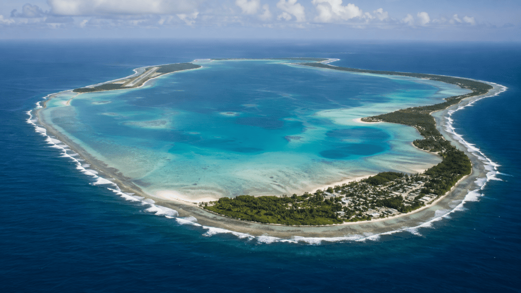Aerial view of a coral atoll, lagoon, airfield and island settlement in the Indian Ocean